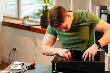 Man assembles a computer system unit at home