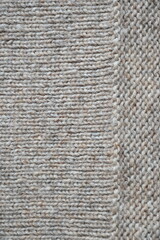 The texture of fabric thick beige sweater close-up. Knitted texture background