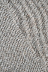 The texture of fabric thick beige sweater close-up. Knitted texture background
