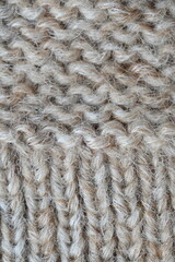  texture of knitted light brown sweater, close-up texture of beige knitted fabric, macro texture of tan knitted woolen clothes   