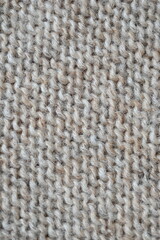  texture of knitted light brown sweater, close-up texture of beige knitted fabric, macro texture of tan knitted woolen clothes   