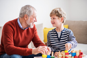 Grandfather spending time with grandson, taking care of him while parents are at work. Boy and...