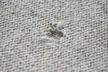 hole in a brown pastel jumper, hole in a tan woollen jumper,	knitted sweater beige texture