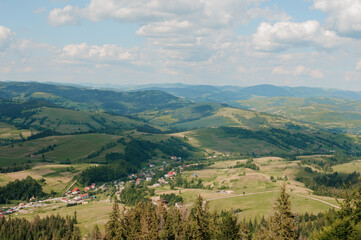 Naklejka premium Scenic Overlook of Rolling Hills and Lush Green Valleys Under a Bright Blue Sky