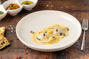 Cheese ravioli with sauces on a white porcelain plate