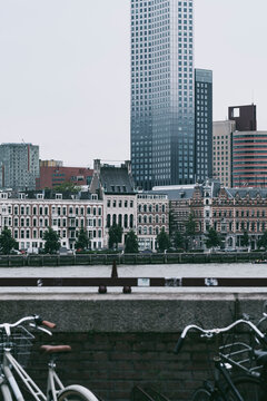 A diverse blend of parked bicycles with a backdrop of traditional Dutch buildings layered against modern skyscrapers, illustrating cultural mix and urban mobility  in Rotterdam