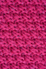 pink texture of knitted wool fabric as a background, smooth symmetrical lines of hand-knitted needlework pattern