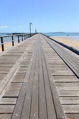 Obraz premium Timber wooden jetty pier, Kingfisher Bay, K'gari Fraser Island, travel tourism destination, summer holiday vacation, camping 4WD outdoor adventure