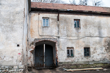 Abandoned Rustic Building with Weathered Stone Walls and a Rusty Gate