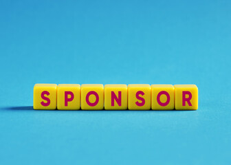 Sponsor word written with toy cubes on blue background