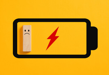 Sad wooden block character inside empty battery icon showing low energy