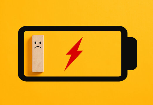 Sad wooden block character inside empty battery icon showing low energy