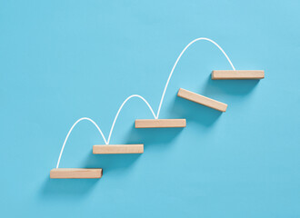 Wooden blocks forming increasing graph on blue background