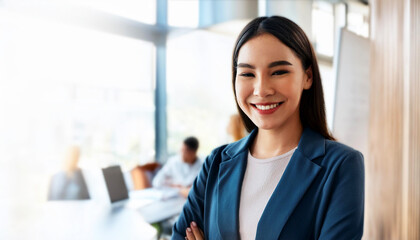 Fototapeta premium businesswoman in a modern office setting. She is smiling, dressed in professional attire, and standing with arms crossed, conveying leadership and professionalism, creative office space