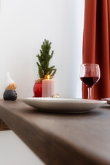 Christmas decoration big pink candle burning and small Christmas tree, home interior