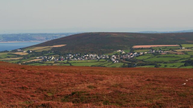 Camera Pan Across Welsh British Countryside Landscape with Moorland Foreground and Llangenith Rural Village with Farmed Fields and Loughor Estuary in Distance 4K