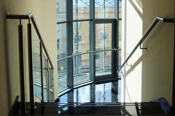 A modern staircase fully glazed, overlooking the old town.