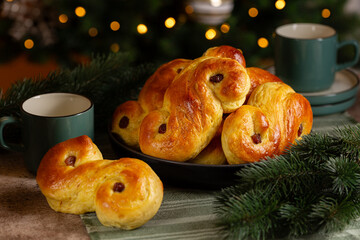 Christmas festive table with homemade swedish St Lucia saffron buns.  Coffe or tea cups. lussekatt...