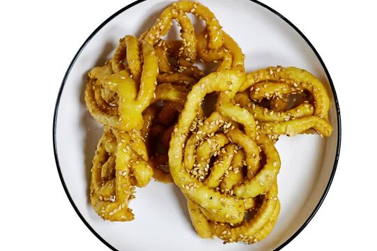 Griwech crunchy pastries , an Algerian dessert made with dough, fried and then coated with syrup and sesame seeds, in morocco named Chebakia isolated on white