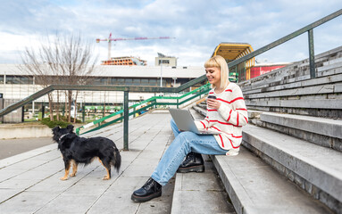 Young woman pet owner spending quality time with her adopted rescued dog outdoor walking and enjoying their friendship. Hipster female with cool attitude youth culture with adopting abandoned animals