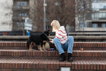 Young woman pet owner spending quality time with her adopted rescued dog outdoor walking and...