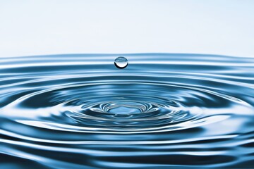 Crystal clear water drop with ripples on blue surface