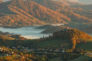 Sunrise in the valley of a beautiful green field in spring with fog. Mountain valley with fog,...
