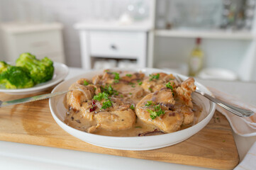 Homemade cooked slices of turkey breast in a delicious onion sauce on kitchen counter