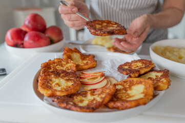 Woman with homemade  fresh pan fried potato quark pancakes. Traditional german Quarkkeulchen