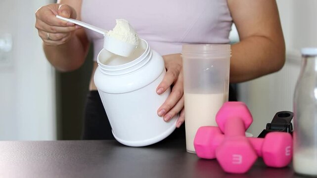 Close up of woman preparing a protein shake in the kitchen. Diet meal replacement for weight loss 