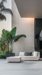 A modern outdoor lounge area with sleek furniture and tropical plants near a contemporary building