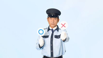 バツ印を見せる男性警備員