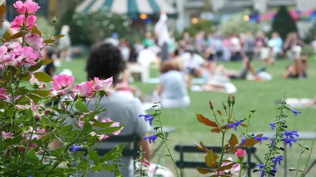 New York City, Manhattan Midtown Bryant Park with Public library, 42 street and 5th Fifth 5 avenue corner, United States. NYC landmark in USA. Chair and table in summer greenery. People on grass lawn.