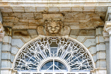 Sculpture of a lion’s head atop a metal structure on the exterior wall of the Royal Palace, Madrid, Spain