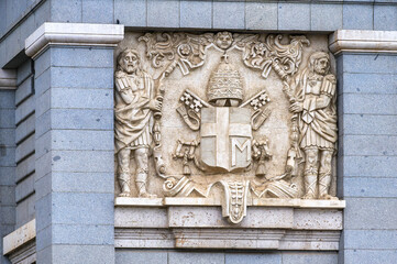 Stone sculpture of a coat of arms on the exterior of Almudena Cathedral, Madrid, Spain