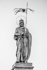 Obraz premium The statue of Saint Wenceslaus towers in Stara Boleslav, Czechia, prominently displaying the saint holding a flag atop a pedestal, symbolizing his historical significance to the region.