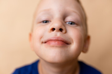 A joyful child smiles brightly against a neutral background, showcasing the innocence and happiness of youth