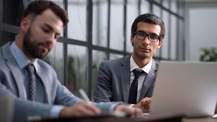 Modern office. Portrait of stylish businessmen working on laptop,