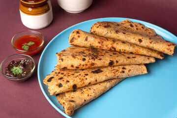Healthy Indian Mooli or Radish paratha or stuffed flatbread with coriander and green chilli chutney on wooden background