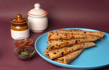 Healthy Indian Mooli or Radish paratha or stuffed flatbread with coriander and green chilli chutney on wooden background