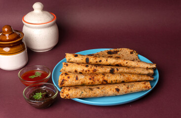 Healthy Indian Mooli or Radish paratha or stuffed flatbread with coriander and green chilli chutney on wooden background