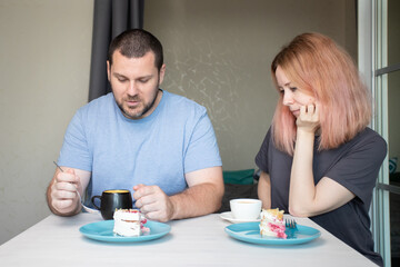 Family dinner, husband and wife drinking coffee and eating cake at home, cosy morning breakfast together, enjoying dessert and coffee, spending quality time around the table.