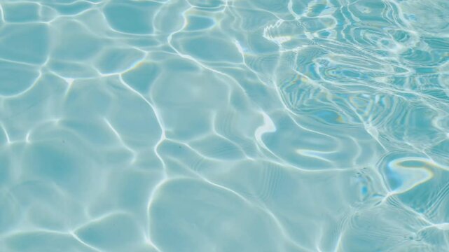 A detailed view of blue water with sunlight creating sparkling reflections and patterns on the calm, rippling surface. Water background. Summer holiday concept
