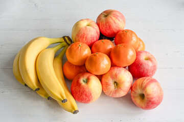 Apples oranges and bananas on a white wooden table