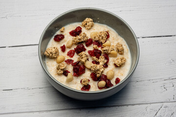 Traditional Scottish breakfast with a modern twist of a bowl of traditional porridge loaded with granola pine nuts and cranberries.