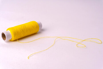 Colorful sewing thread set and needles isolated on background.