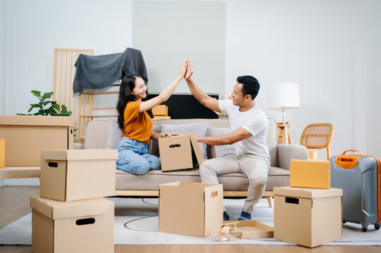 Asian young attractive couple man and woman use tablet and smartphone online shopping furniture decorate house with carton package move in new house. Young married asian moving home. . - Powered by Adobe