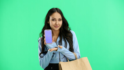 Woman, close-up, on a green background, with bags and a phone