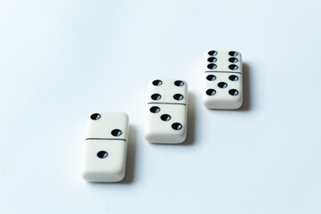 The game of dominoes is a table game involving rectangular pieces with dots that represent numbers. The objective is to match tiles with matching numbers. Photo with white background.