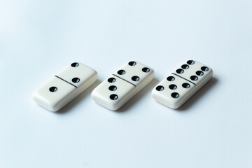 The game of dominoes is a table game involving rectangular pieces with dots that represent numbers. The objective is to match tiles with matching numbers. Photo with white background.